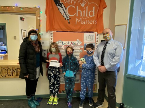 Principal and three students presenting a cheque to the food bank