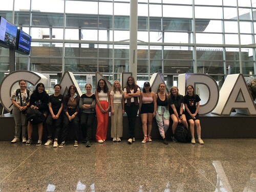 12 students line up in front of a Canada sign