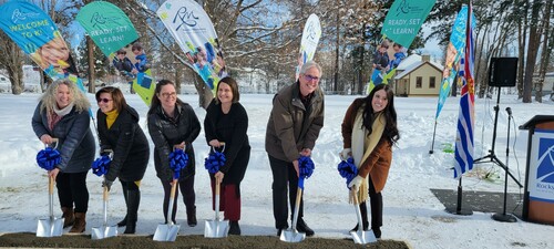 Six middle aged adults with shovels in a sand box