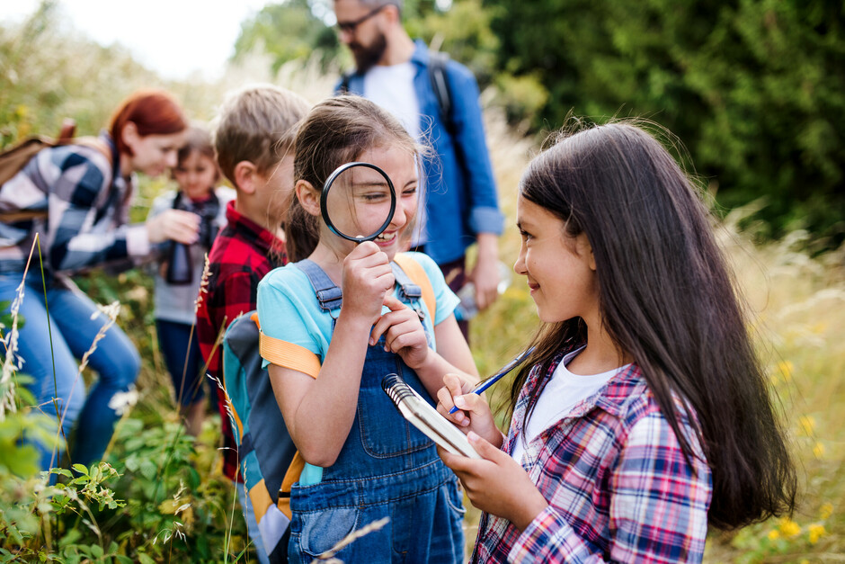 Children outside with magnifying glass