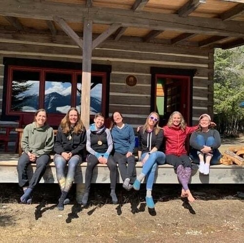 Seven women sitting on a porch posing for a picture