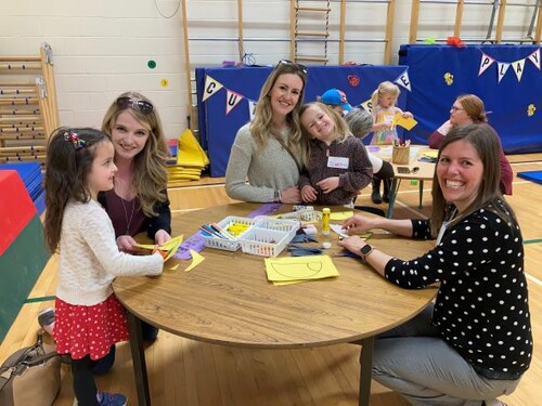 Three female adults with two four year old girls making crafts