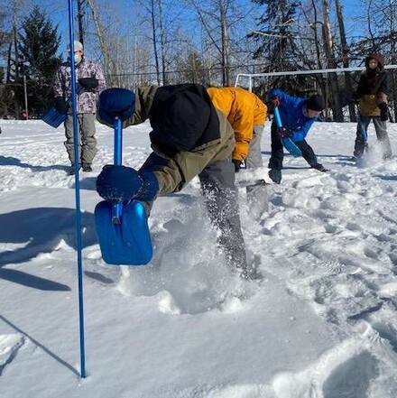 A student shoveling snow in the school playground