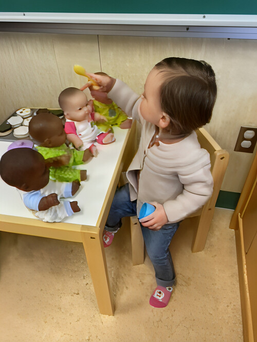 Toddler playing with dolls